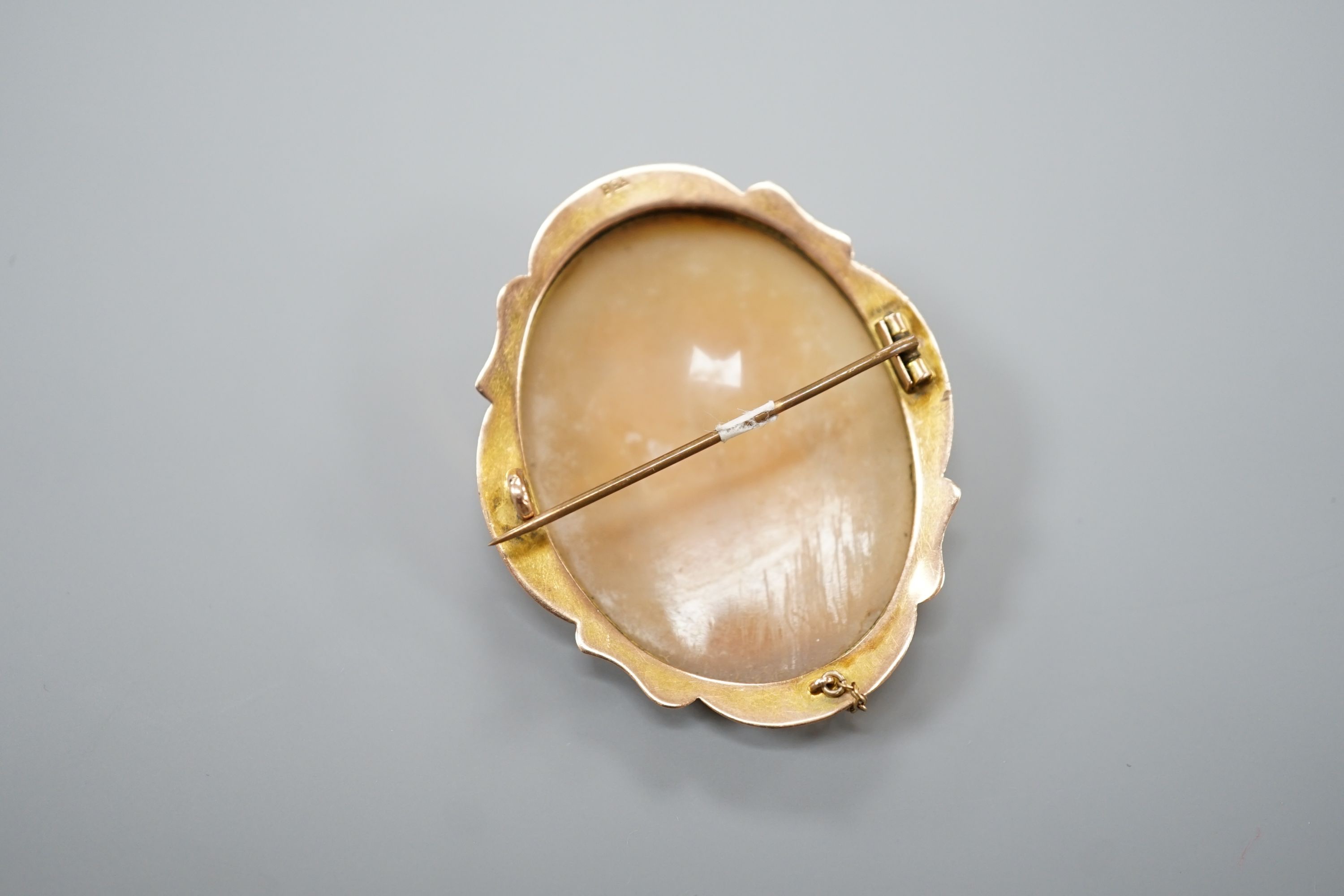 A 9ct mounted oval cameo shell brooch, decorated with two maidens, 46mm, gross 8.9 grams.